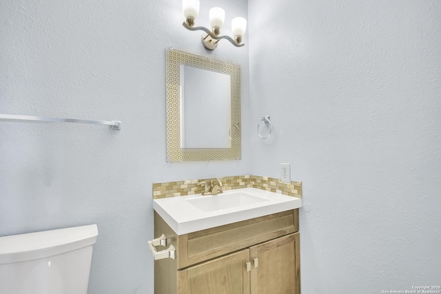 11202 Candle Park, San Antonio, TX 78249 - half bathroom featuring vanity, toilet, and decorative backsplash