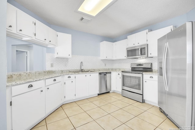 11202 Candle Park, San Antonio, TX 78249 - kitchen featuring stainless steel appliances, a sink, decorative backsplash, white cabinetry, and light tile patterned floors