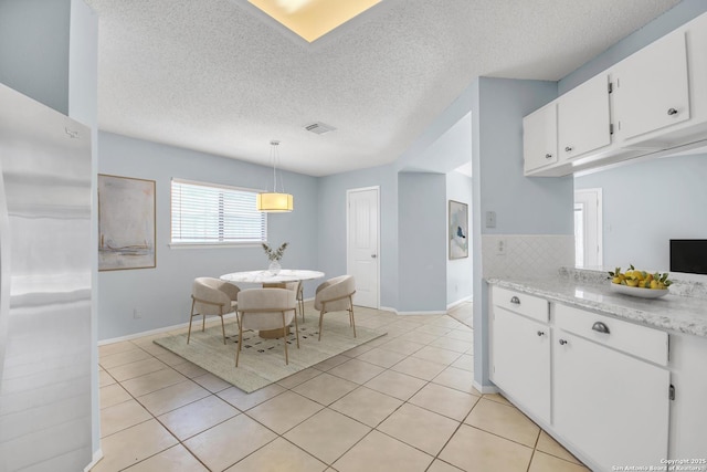 11202 Candle Park, San Antonio, TX 78249 - dining space featuring light tile patterned floors, baseboards, and a textured ceiling
