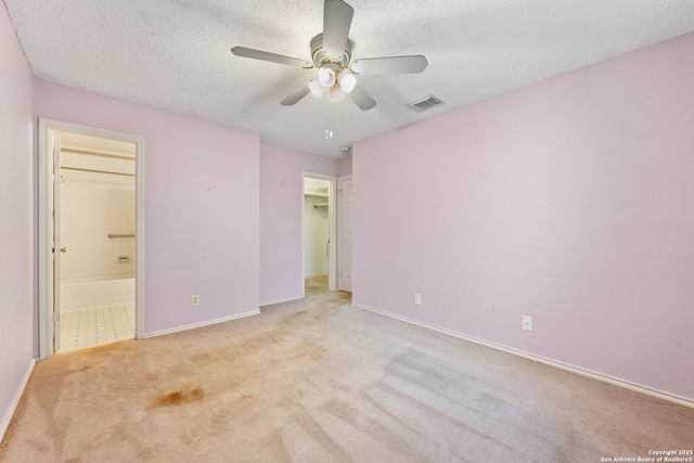 6826 Evercrest, San Antonio, TX 78239 - unfurnished bedroom with carpet flooring, ensuite bathroom, baseboards, a textured ceiling, and a walk in closet