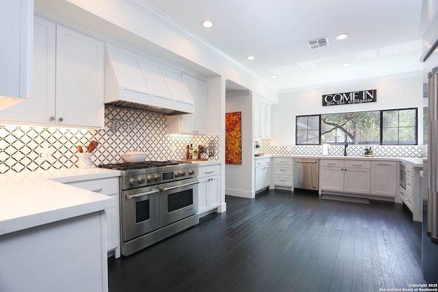 8306 Country Side, San Antonio, TX 78209 - kitchen with appliances with stainless steel finishes, wall chimney exhaust hood, white cabinets, crown molding, and recessed lighting