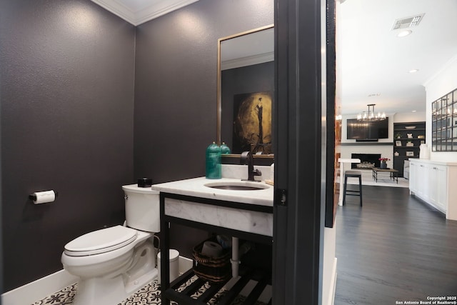 8306 Country Side, San Antonio, TX 78209 - half bathroom with toilet, ornamental molding, baseboards, a chandelier, and a fireplace with raised hearth