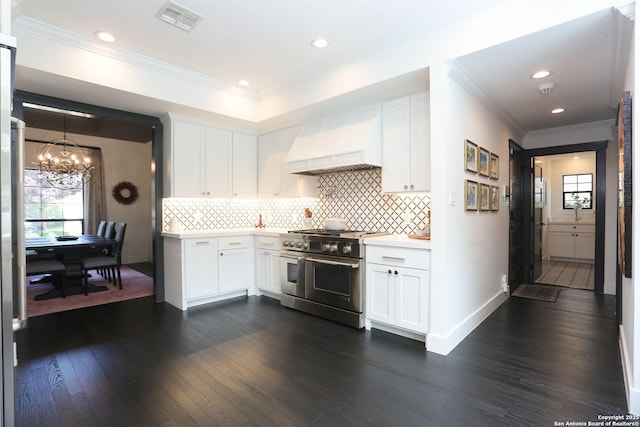 8306 Country Side, San Antonio, TX 78209 - kitchen featuring double oven range, wall chimney range hood, plenty of natural light, light countertops, and crown molding