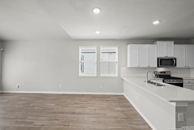 12942 Irvin Path, San Antonio, TX 78254 - kitchen featuring stainless steel appliances, a sink, decorative backsplash, light countertops, and light wood-style floors