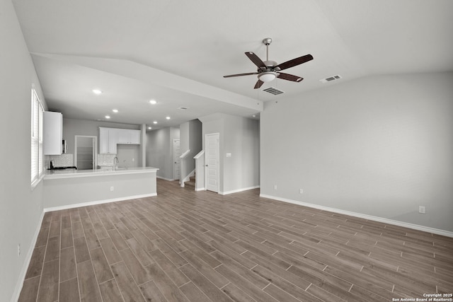 12942 Irvin Path, San Antonio, TX 78254 - unfurnished living room featuring lofted ceiling, stairs, a ceiling fan, wood finished floors, and baseboards