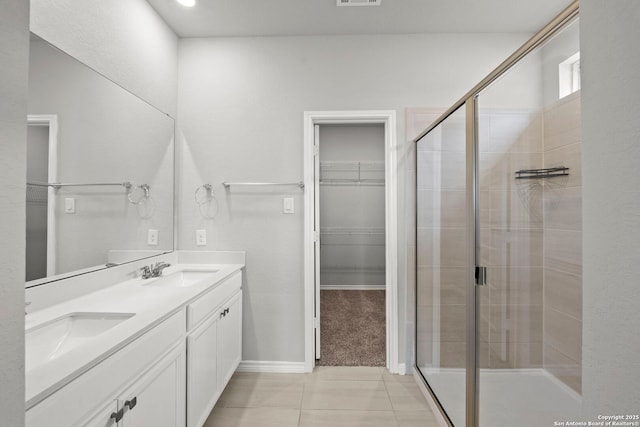 12942 Irvin Path, San Antonio, TX 78254 - full bath with double vanity, a stall shower, a spacious closet, and tile patterned floors