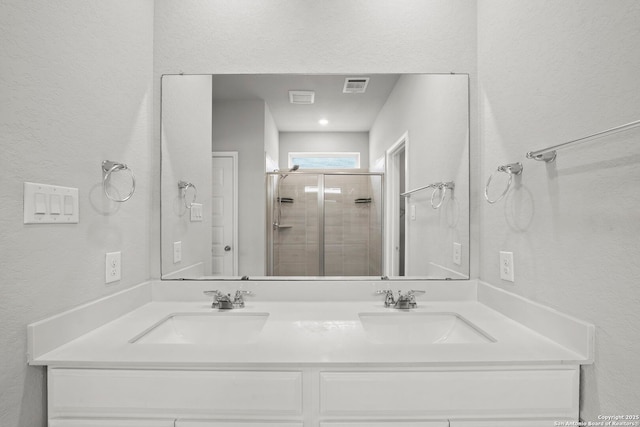 12942 Irvin Path, San Antonio, TX 78254 - full bath featuring double vanity, a textured wall, and a stall shower