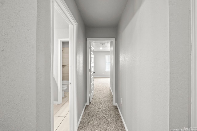 12942 Irvin Path, San Antonio, TX 78254 - hallway with baseboards, light colored carpet, and a textured wall
