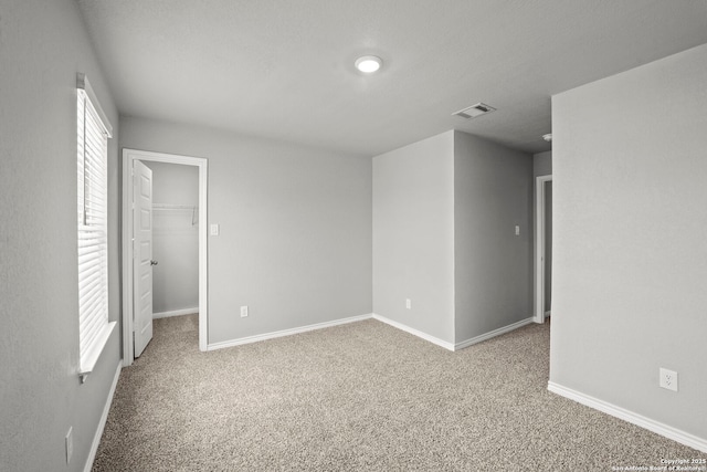 12942 Irvin Path, San Antonio, TX 78254 - unfurnished bedroom with carpet flooring, baseboards, and a walk in closet
