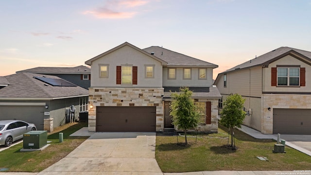 12942 Irvin Path, San Antonio, TX 78254 - view of front of property with stone siding, concrete driveway, an attached garage, a lawn, and stucco siding