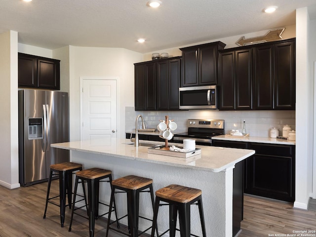 204 Dakota Rdg, Cibolo, TX 78108 - kitchen featuring appliances with stainless steel finishes, a sink, a kitchen breakfast bar, light wood finished floors, and recessed lighting