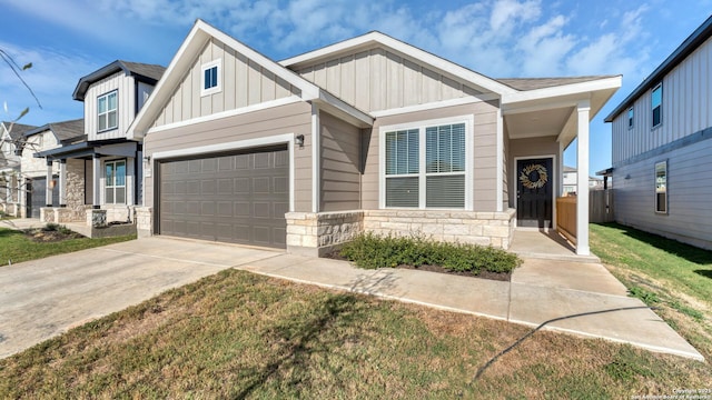 729 Heartseed Ave, New Braunfels, TX 78130 - view of front of house featuring board and batten siding, stone siding, concrete driveway, and a garage