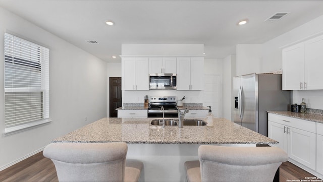 729 Heartseed Ave, New Braunfels, TX 78130 - kitchen featuring appliances with stainless steel finishes, a sink, a kitchen island with sink, white cabinets, and dark wood-type flooring