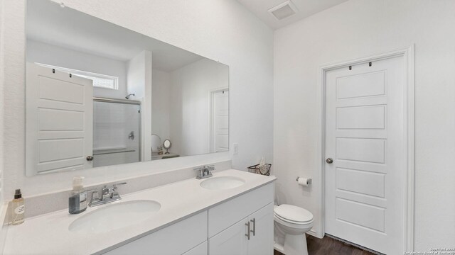 729 Heartseed Ave, New Braunfels, TX 78130 - bathroom featuring an enclosed shower, toilet, double vanity, and wood finished floors