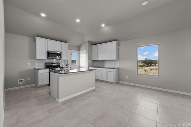 6228 Persimmon Lk, San Antonio, TX 78254 - kitchen featuring stainless steel appliances, decorative backsplash, lofted ceiling, a center island with sink, and white cabinetry