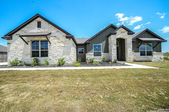 5721 Provo Pl, San Antonio, TX 78263 - view of front of house featuring board and batten siding, a front yard, and stone siding