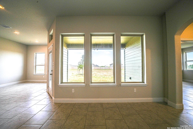 5721 Provo Pl, San Antonio, TX 78263 - empty room with arched walkways, healthy amount of natural light, baseboards, and recessed lighting