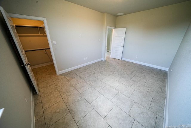 5721 Provo Pl, San Antonio, TX 78263 - unfurnished bedroom featuring a spacious closet, tile patterned flooring, a closet, and baseboards