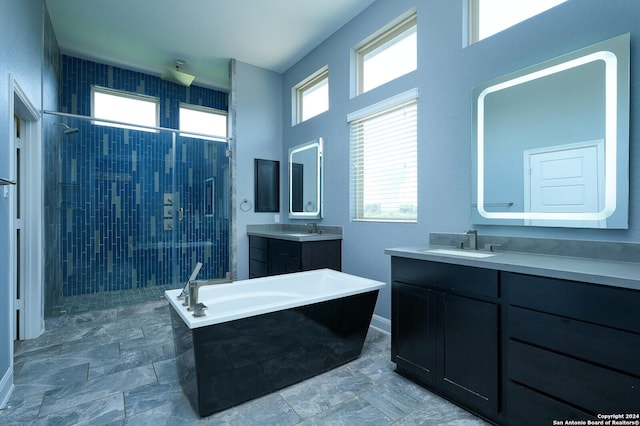 24342 Mateo Rdg, San Antonio, TX 78261 - full bath with tiled shower, a tub to relax in, two vanities, and baseboards
