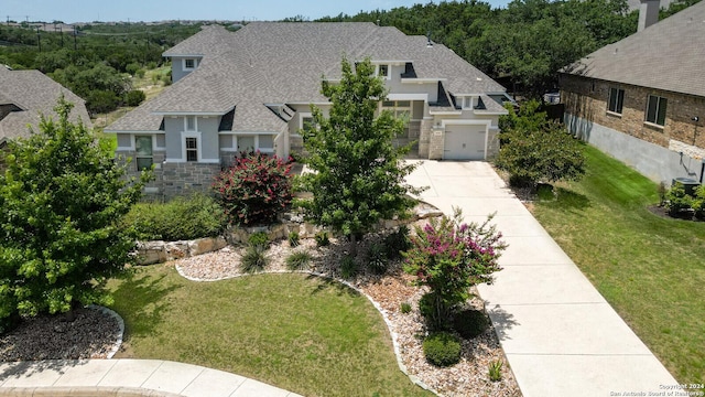 24342 Mateo Rdg, San Antonio, TX 78261 - view of front of property featuring roof with shingles, driveway, stone siding, stucco siding, and a front lawn