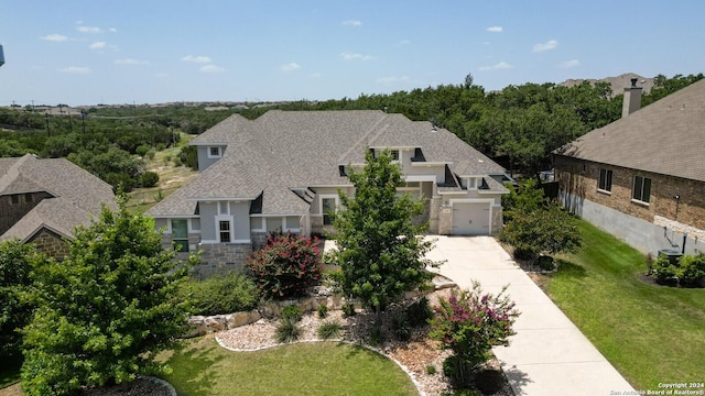 24342 Mateo Rdg, San Antonio, TX 78261 - view of front facade featuring roof with shingles, driveway, and a front yard