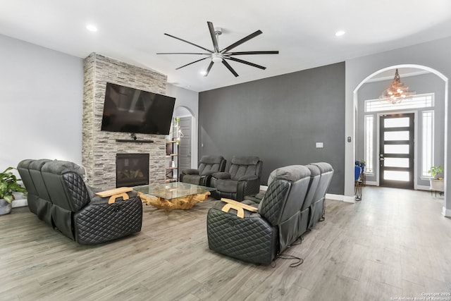 24342 Mateo Rdg, San Antonio, TX 78261 - living room featuring arched walkways, a ceiling fan, wood finished floors, a stone fireplace, and recessed lighting
