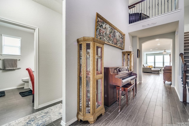 7604 Pecos Rdg, Boerne, TX 78015 - hallway featuring wood tiled floors, arched walkways, baseboards, and a towering ceiling