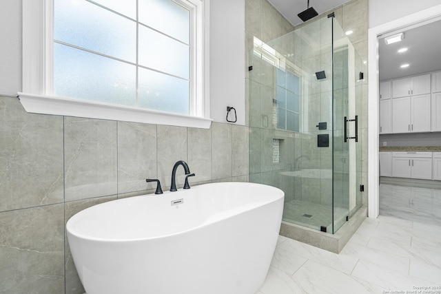 3828 Palomino Spgs, Bandera, TX 78003 - full bathroom featuring a stall shower, a freestanding tub, tile walls, and healthy amount of natural light