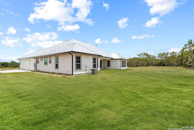 3828 Palomino Spgs, Bandera, TX 78003 - rear view of house featuring an attached garage, central AC, concrete driveway, stucco siding, and a yard