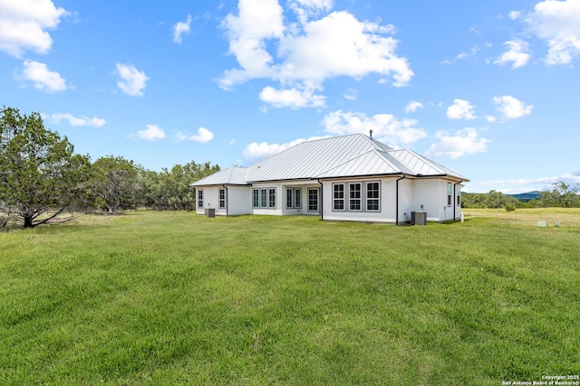 3828 Palomino Spgs, Bandera, TX 78003 - rear view of property with central AC unit, a lawn, a standing seam roof, and metal roof