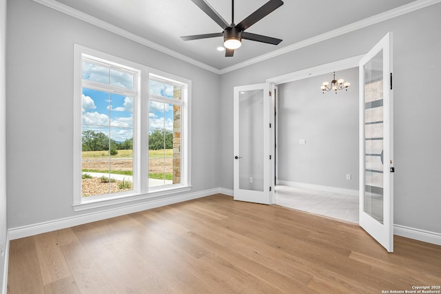 3828 Palomino Spgs, Bandera, TX 78003 - empty room with french doors, a chandelier, light wood-type flooring, crown molding, and a ceiling fan