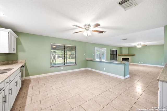 6119 Ferrysage, San Antonio, TX 78244 - kitchen featuring a ceiling fan, open floor plan, white cabinetry, light tile patterned flooring, and a textured ceiling
