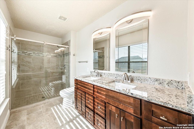 6119 Ferrysage, San Antonio, TX 78244 - bathroom with toilet, double vanity, a stall shower, and a textured ceiling