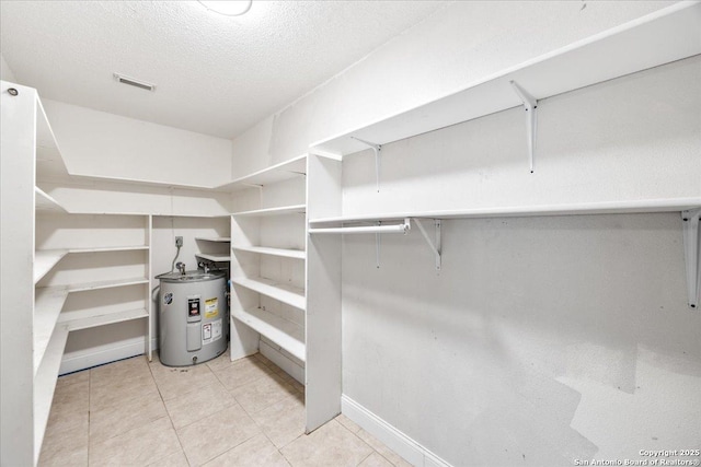 6119 Ferrysage, San Antonio, TX 78244 - walk in closet featuring water heater and light tile patterned floors