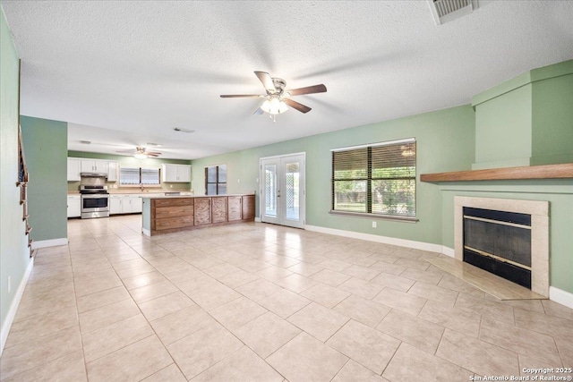 6119 Ferrysage, San Antonio, TX 78244 - unfurnished living room with a ceiling fan, baseboards, a tile fireplace, a textured ceiling, and light tile patterned floors