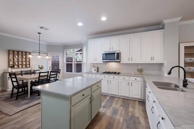 830 Emerald Bay, San Antonio, TX 78260 - kitchen with stainless steel microwave, a sink, wood finished floors, crown molding, and gas cooktop