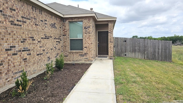 5930 Foster Bnd, San Antonio, TX 78244 - view of exterior entry featuring brick siding and a shingled roof