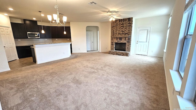 5930 Foster Bnd, San Antonio, TX 78244 - kitchen featuring stainless steel microwave, ceiling fan, light carpet, arched walkways, and decorative backsplash
