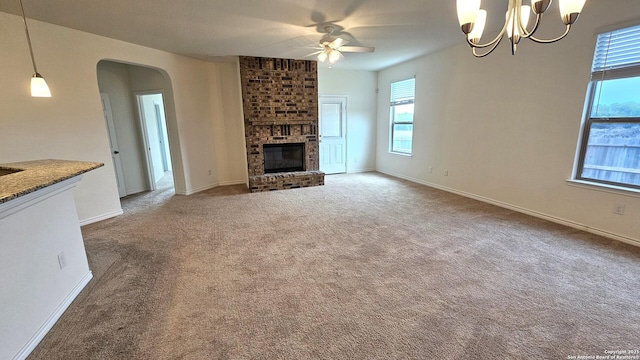5930 Foster Bnd, San Antonio, TX 78244 - unfurnished living room featuring ceiling fan, arched walkways, a brick fireplace, carpet floors, and baseboards