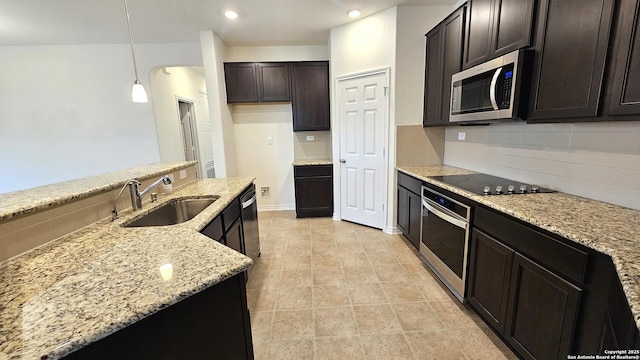 5930 Foster Bnd, San Antonio, TX 78244 - kitchen featuring appliances with stainless steel finishes, a sink, tasteful backsplash, light stone counters, and dark brown cabinets