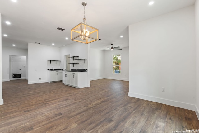 101 New York, San Antonio, TX 78214 - unfurnished living room featuring a chandelier, recessed lighting, baseboards, dark wood-style flooring, and a ceiling fan