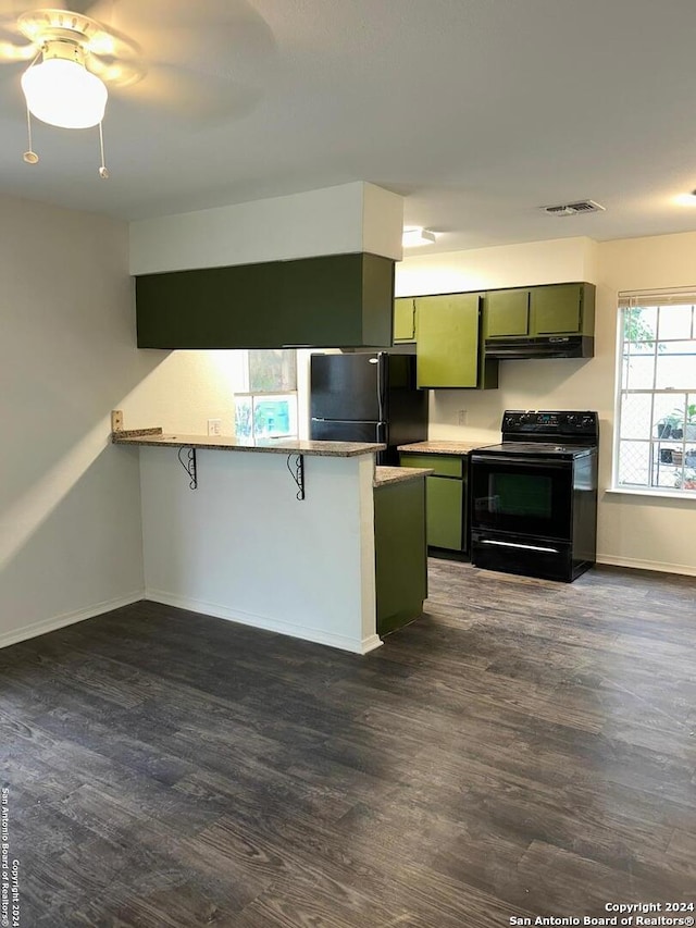 1807 Fresno, San Antonio, TX 78201 - kitchen with black appliances, green cabinetry, under cabinet range hood, a peninsula, and dark wood finished floors