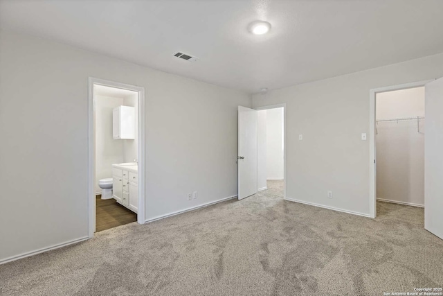1011 Cat Mesa, San Antonio, TX 78251 - unfurnished bedroom featuring carpet flooring, a walk in closet, baseboards, ensuite bathroom, and a closet