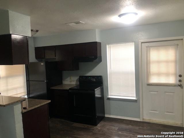 1811 Fresno, San Antonio, TX 78201 - kitchen with black appliances, dark wood-type flooring, baseboards, and a textured ceiling