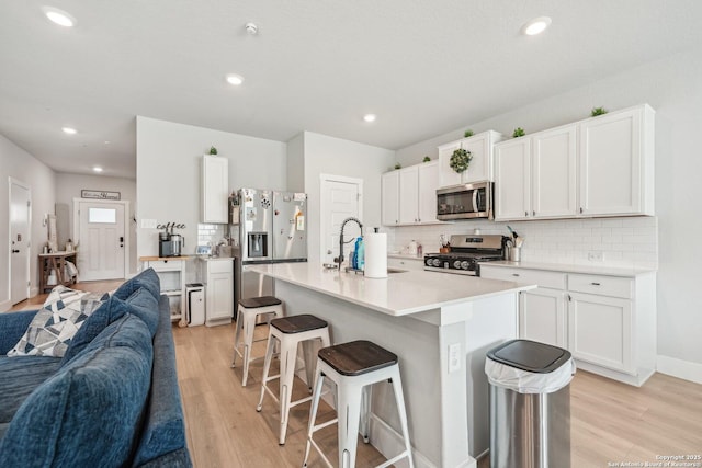 4538 Nueces, San Antonio, TX 78253 - kitchen featuring stainless steel appliances, open floor plan, a breakfast bar area, backsplash, and light wood finished floors