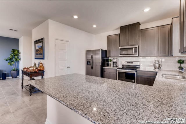 3951 Gentle Mdw, New Braunfels, TX 78130 - kitchen with appliances with stainless steel finishes, light stone countertops, a sink, backsplash, and recessed lighting