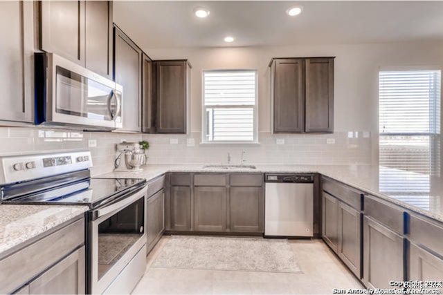 3951 Gentle Mdw, New Braunfels, TX 78130 - kitchen featuring appliances with stainless steel finishes, a sink, backsplash, recessed lighting, and light stone counters