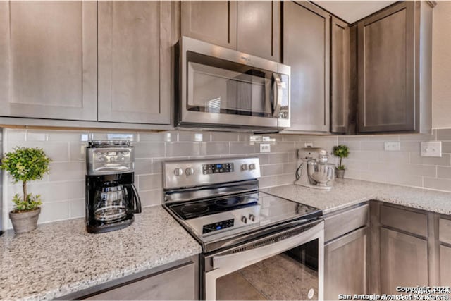3951 Gentle Mdw, New Braunfels, TX 78130 - kitchen with stainless steel appliances, decorative backsplash, and light stone countertops