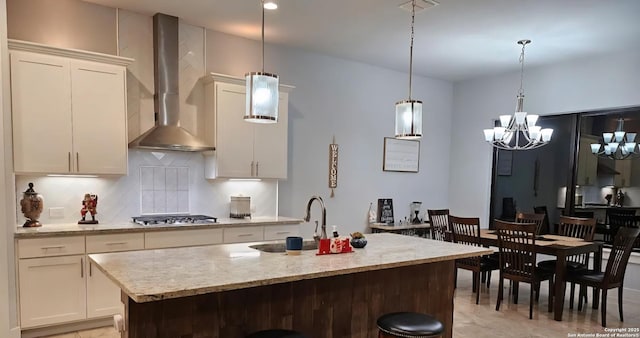1726 Claudia Vis, San Antonio, TX 78224 - kitchen with wall chimney exhaust hood, stainless steel gas stovetop, a chandelier, decorative backsplash, and white cabinets