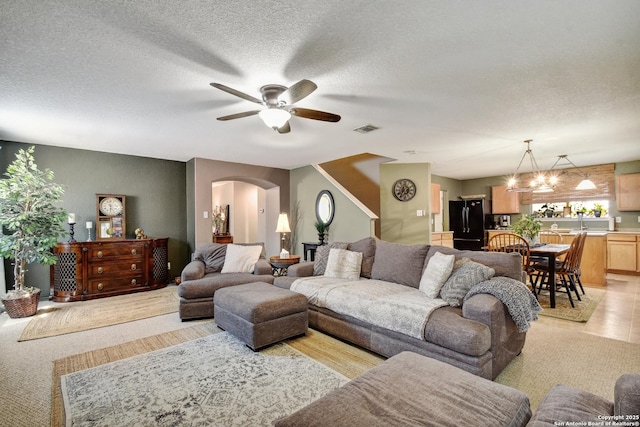 181 Foxglove, Cibolo, TX 78108 - living area with arched walkways, ceiling fan, and a textured ceiling